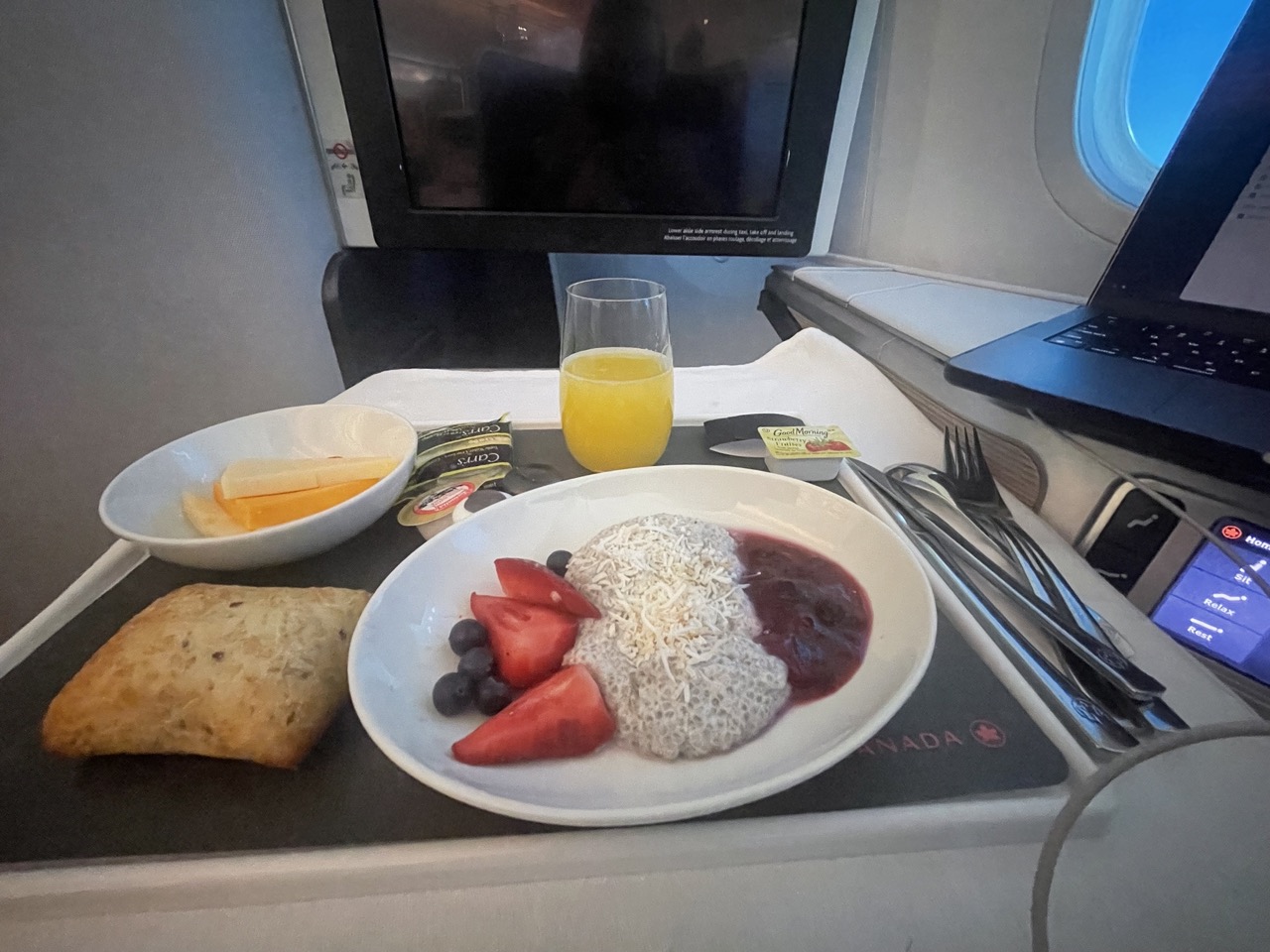 airplane breakfast with juice, berries, and a pastry 